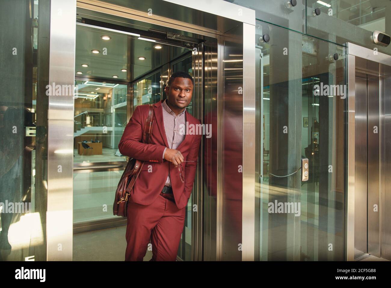 business group comes out from glass Elevator Stock Photo