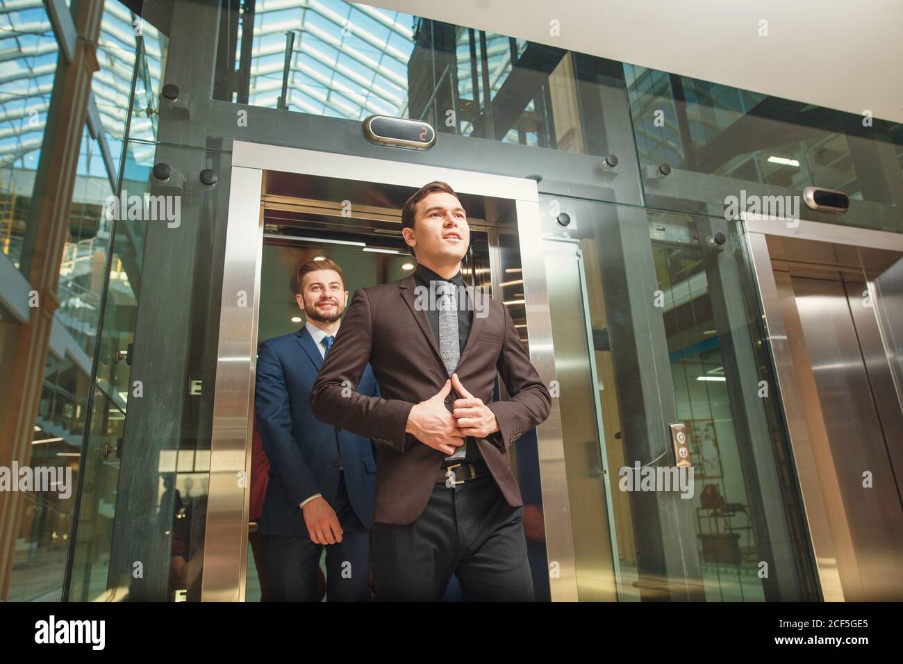 business group comes out from glass Elevator Stock Photo