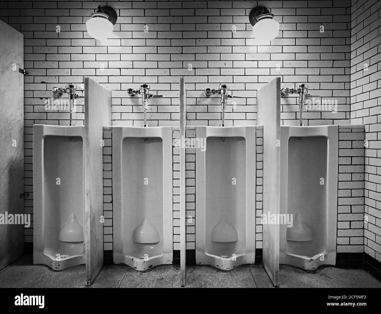 Interior of illuminated public restroom with brick wall in public building of New York City ...