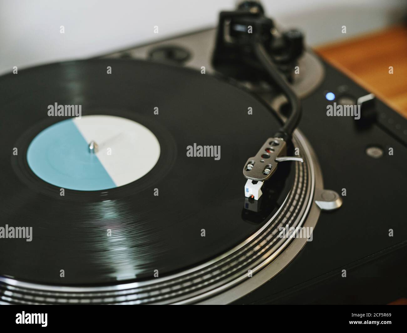 From above contemporary vinyl record player with retro disc placed on wooden table in living room Stock Photo