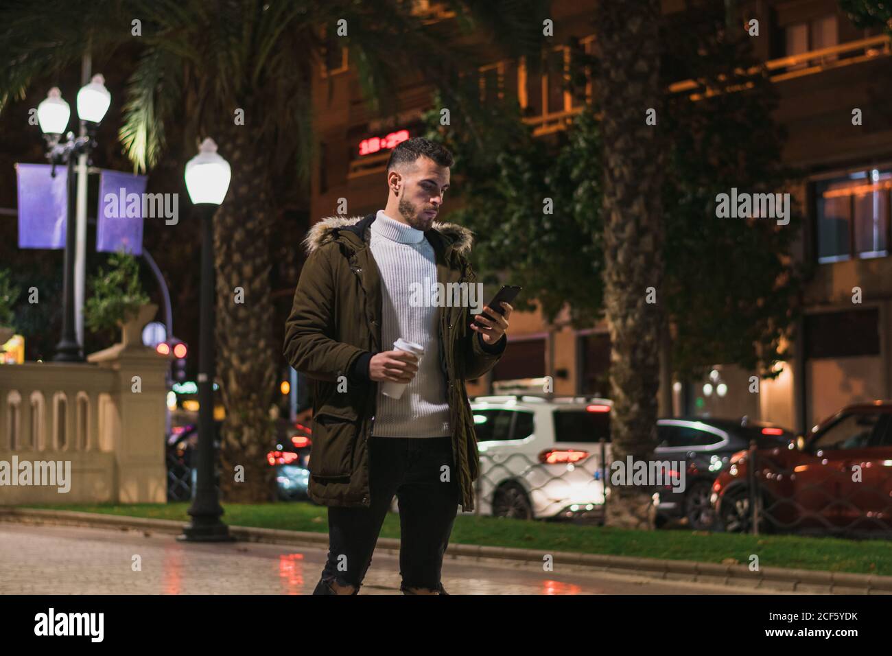 Serious young man using smartphone in street Stock Photo