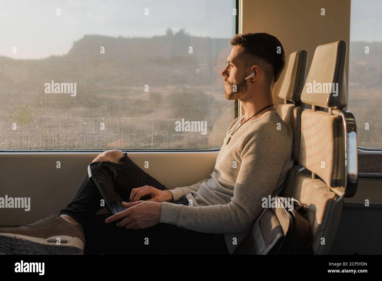 Concentrated male passenger using laptop in train Stock Photo Alamy