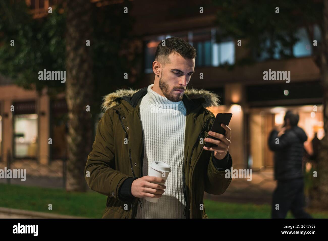 Serious young man using smartphone in street Stock Photo