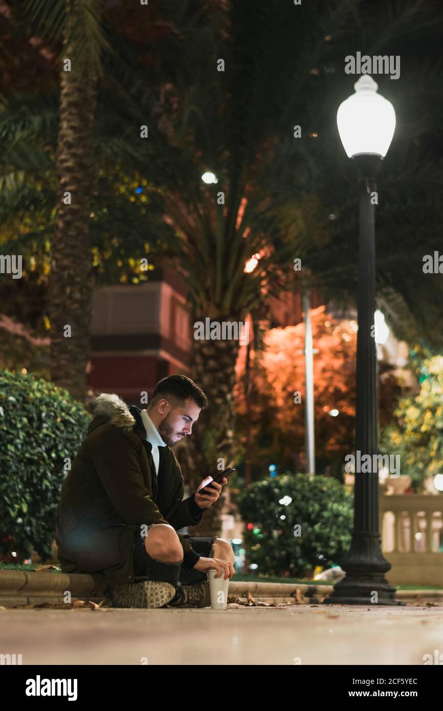 Serious young man using smartphone in street Stock Photo
