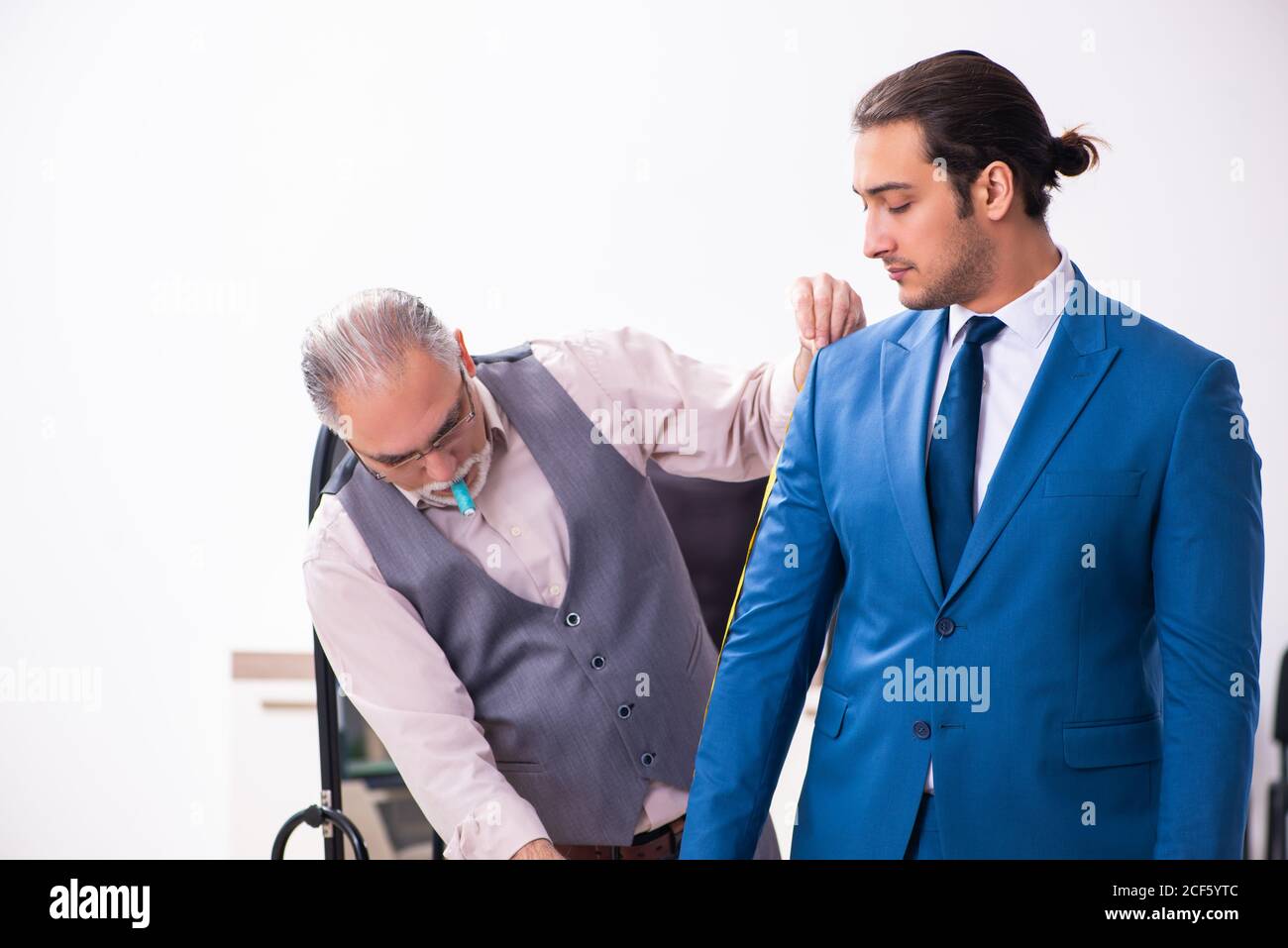 Young businessman visiting old tailor Stock Photo