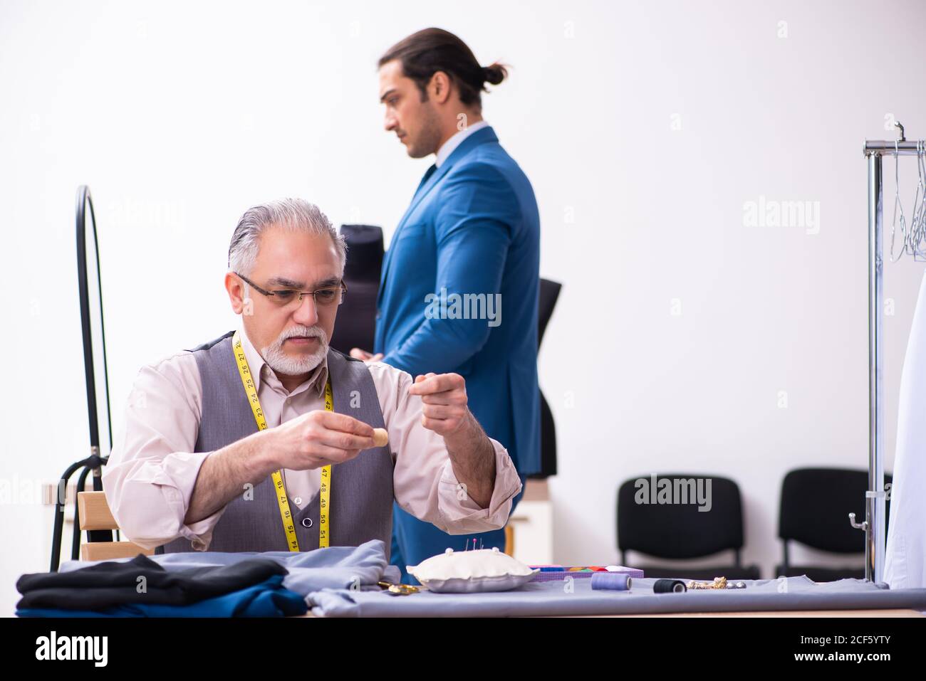 Young businessman visiting old tailor Stock Photo