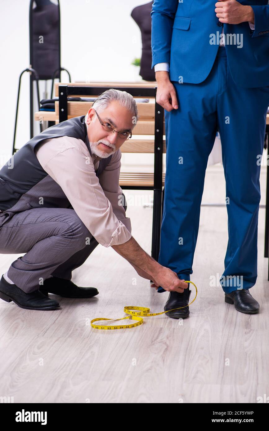 Young businessman visiting old tailor Stock Photo