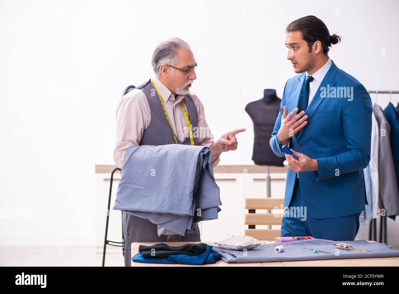 Young businessman visiting old tailor Stock Photo