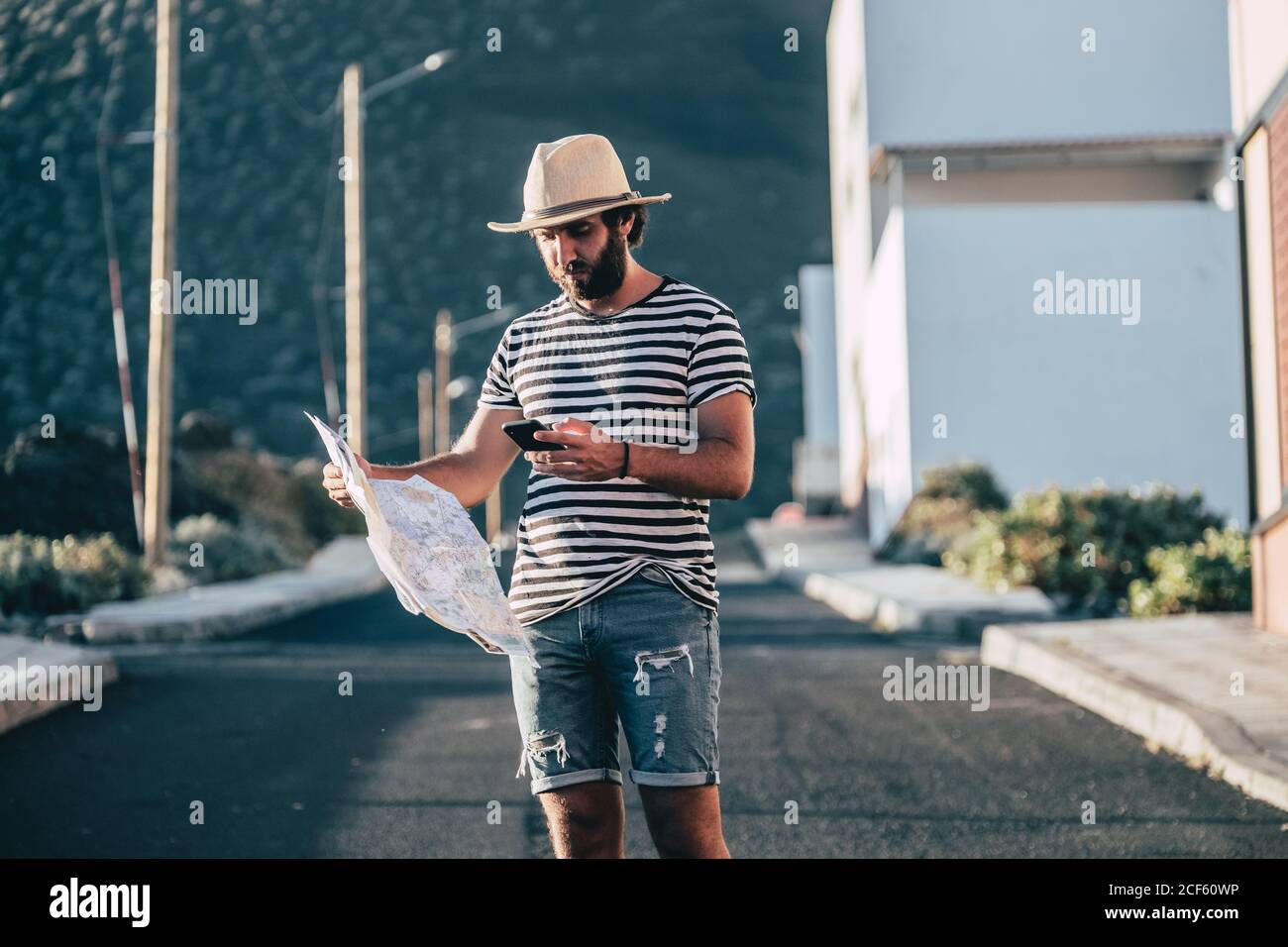 Male traveler standing with map and smartphone Stock Photo