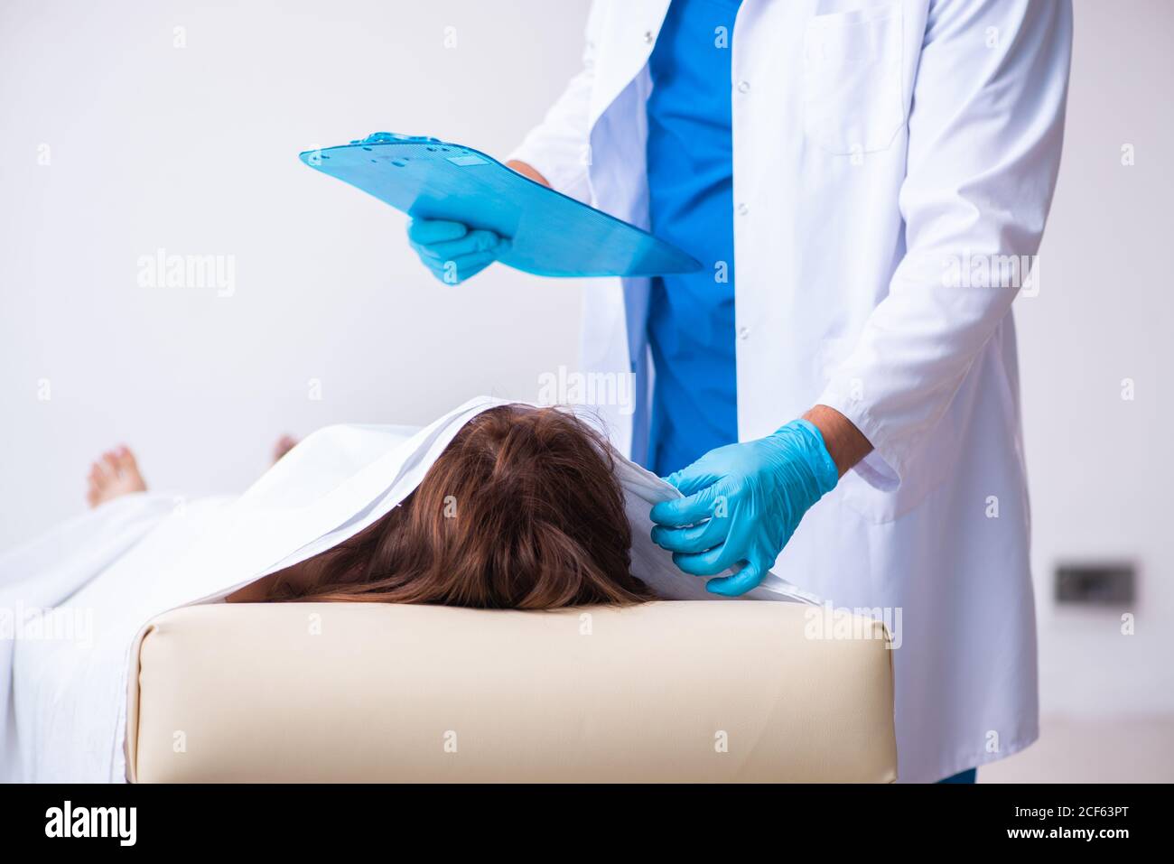 Police coroner examining dead body in morgue Stock Photo