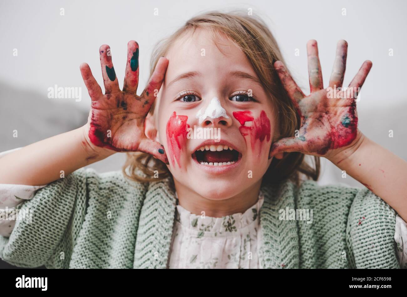 girl with dirty hands coloring face Stock Photo
