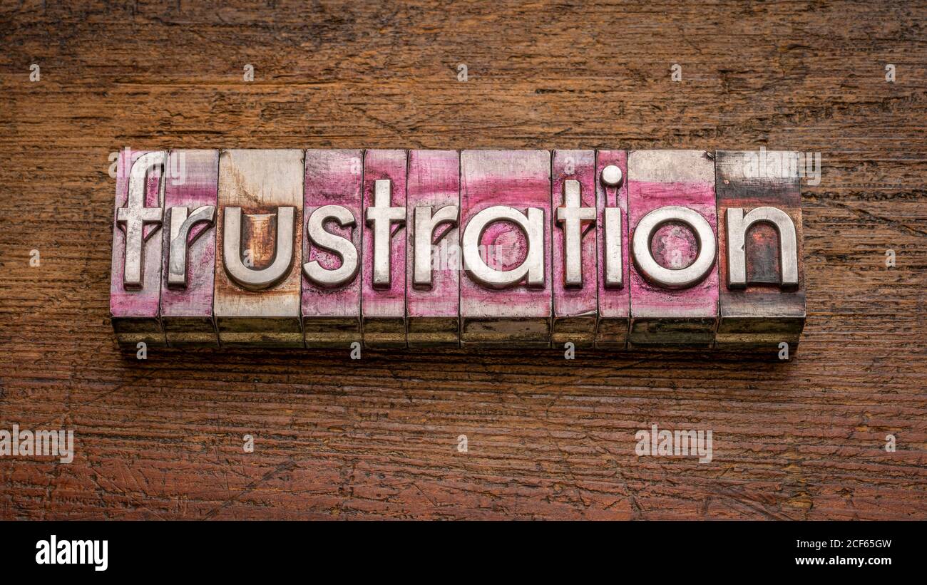 frustration word abstract in gritty vintage letterpress metal type stained by printing ink against rustic wood, negative emotion Stock Photo