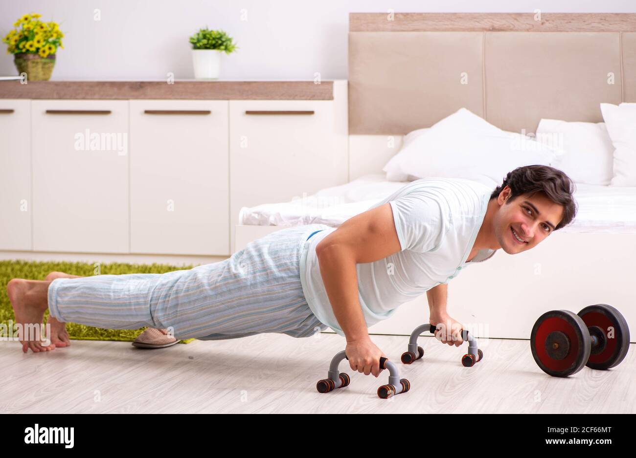 The young man doing morning routine in bedroom Stock Photo - Alamy