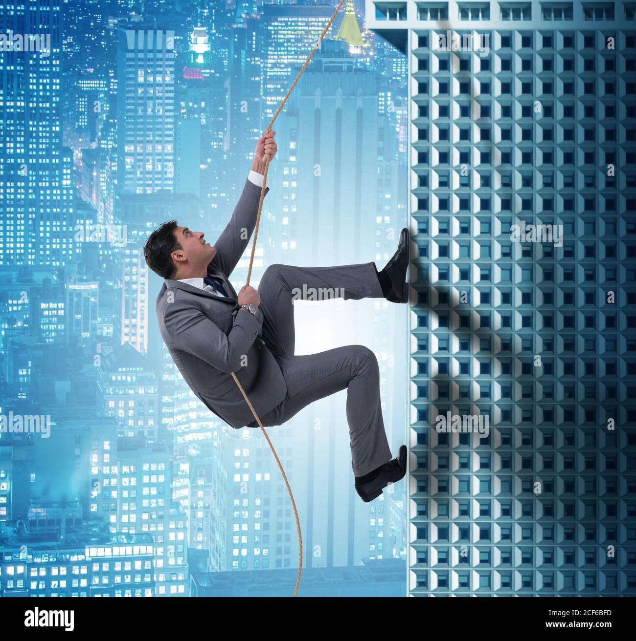 Businessman climbing skyscraper in challenge concept Stock Photo