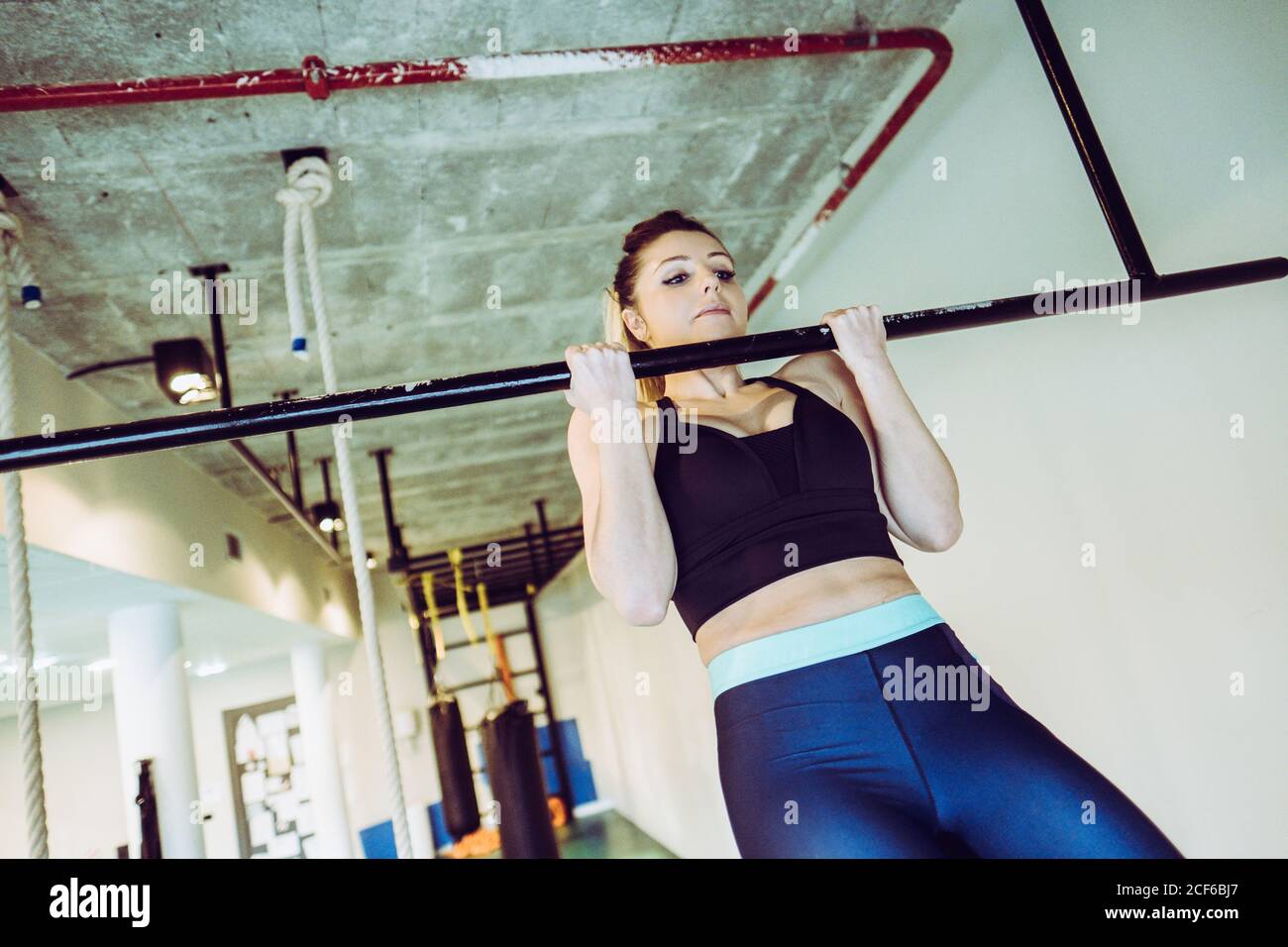 Young Woman doing pull ups in gym Stock Photo - Alamy