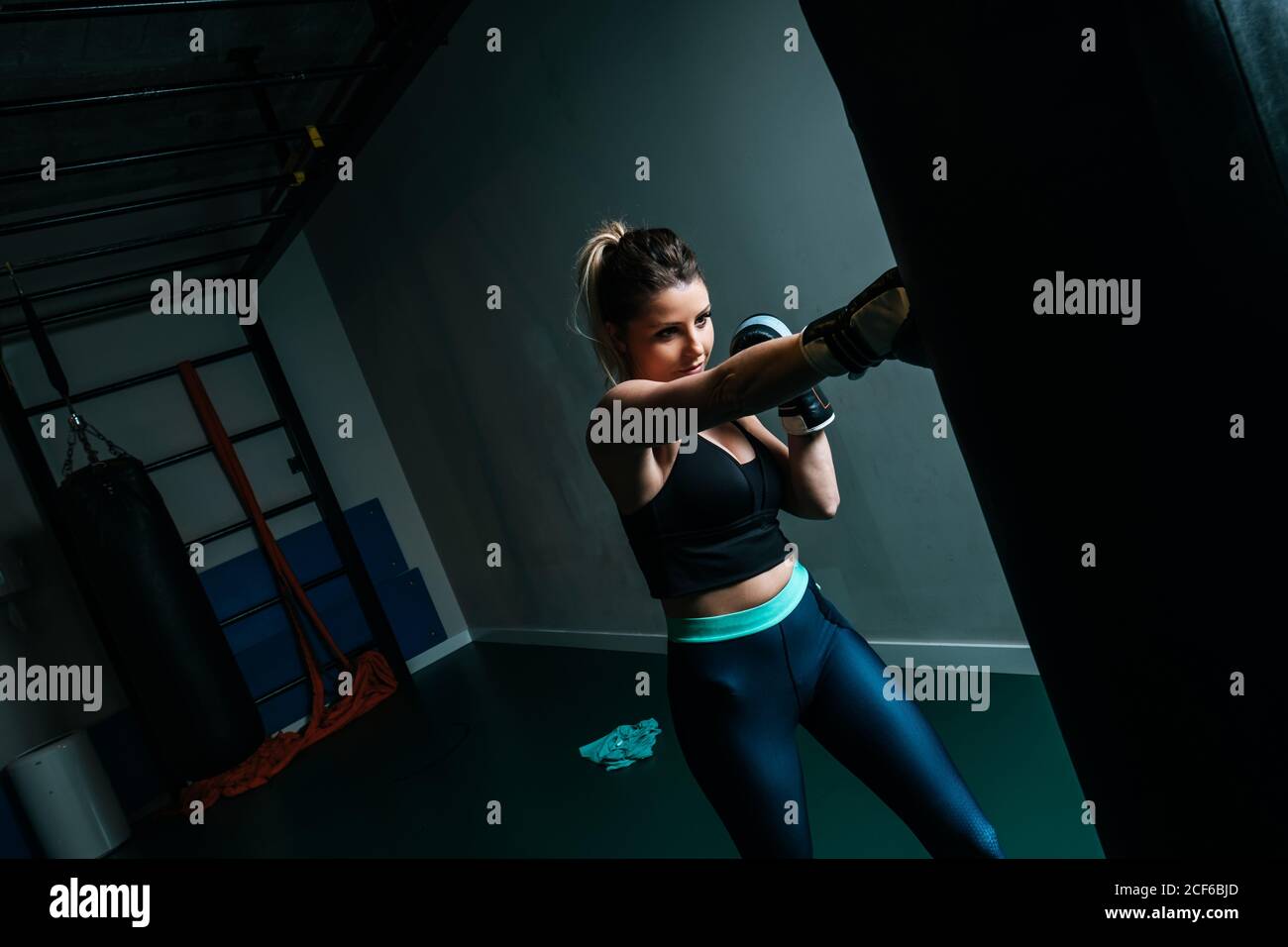 Woman training in gym with punching bag Stock Photo