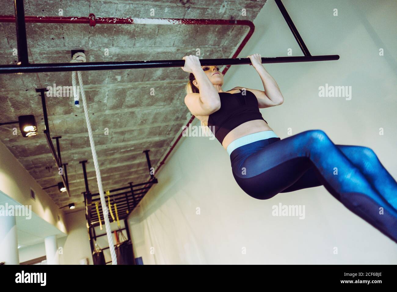 Young Woman doing pull ups in gym Stock Photo - Alamy