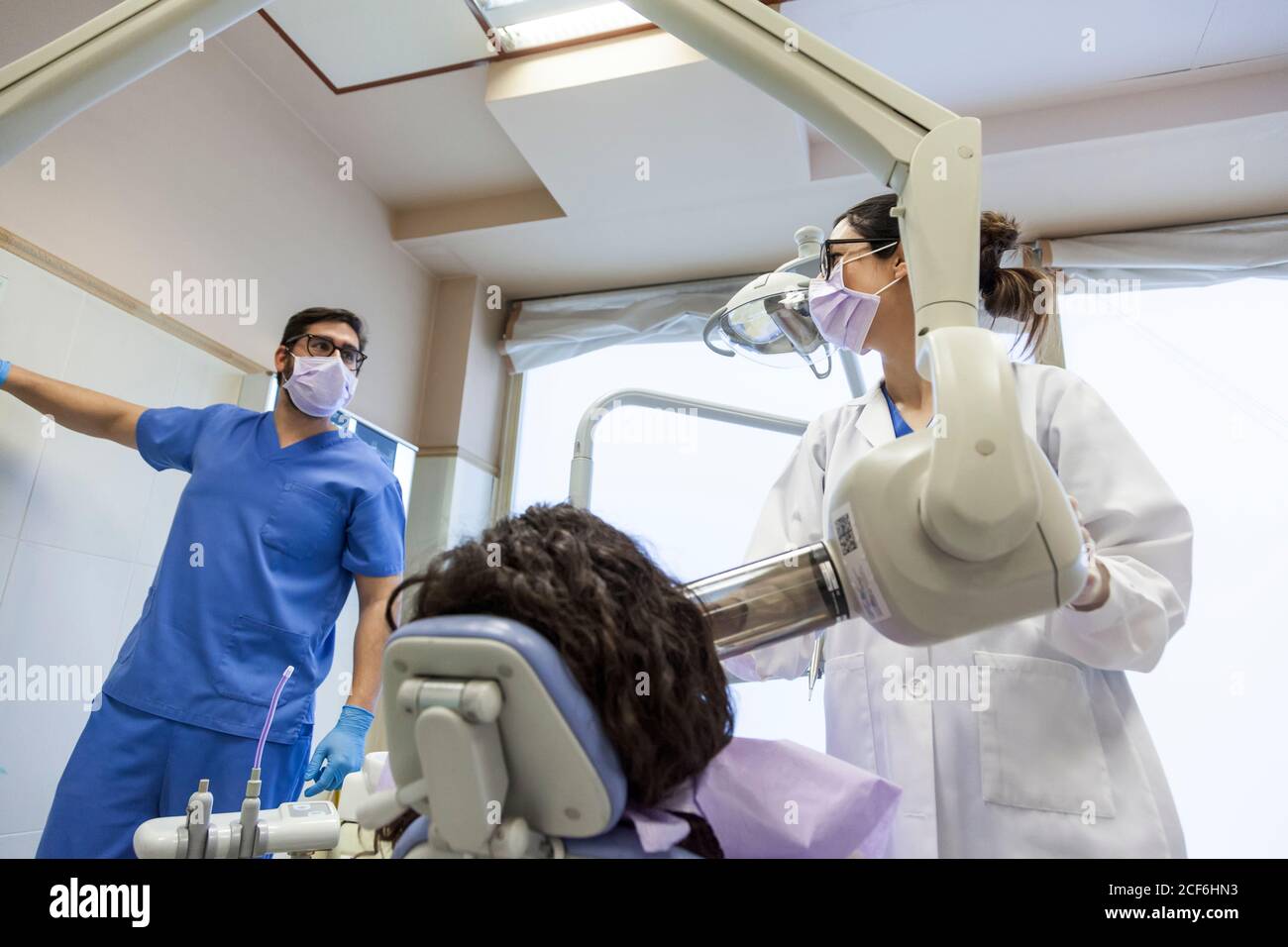 dentist and his assistant taking an xray of the patient's dentition