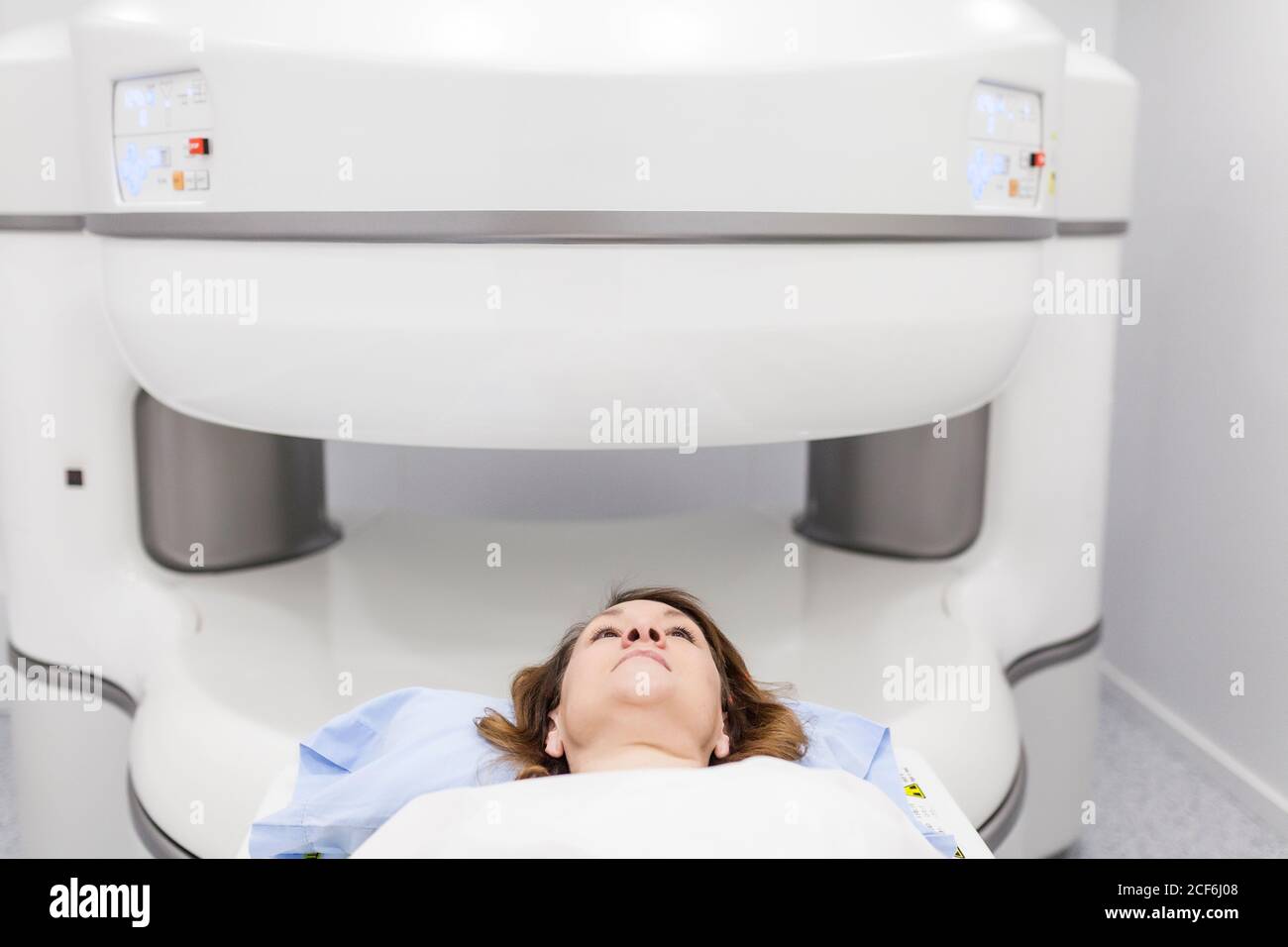 middle-aged Woman on an open MRI machine waiting for the test to begin Stock Photo