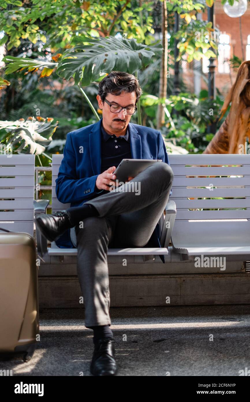 Aged handsome man using digital tablet outdoors Stock Photo