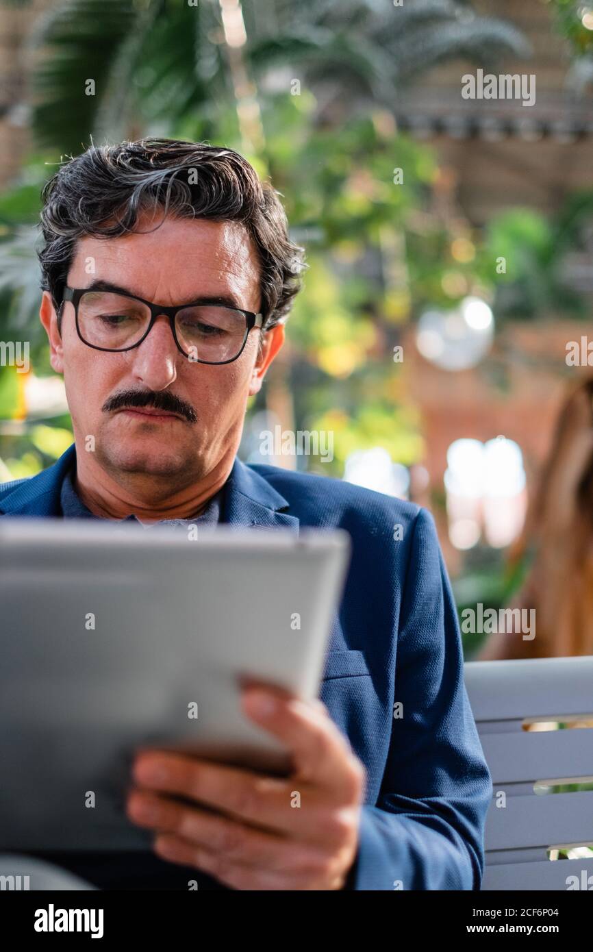 Aged handsome man using digital tablet outdoors Stock Photo