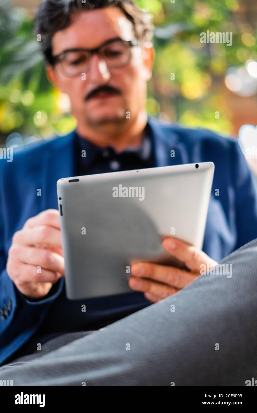 Aged handsome man using digital tablet outdoors Stock Photo