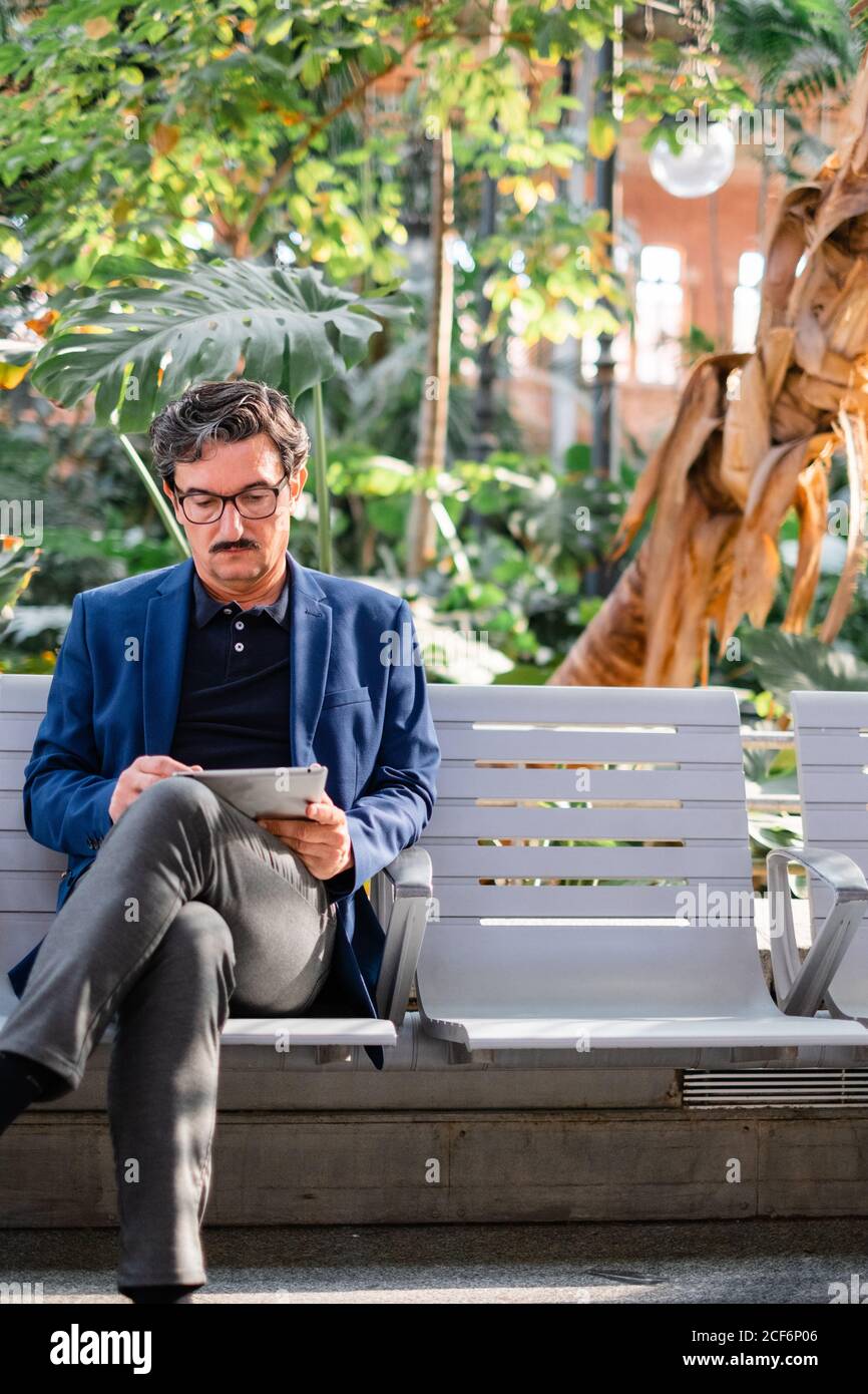 Aged handsome man using digital tablet outdoors Stock Photo