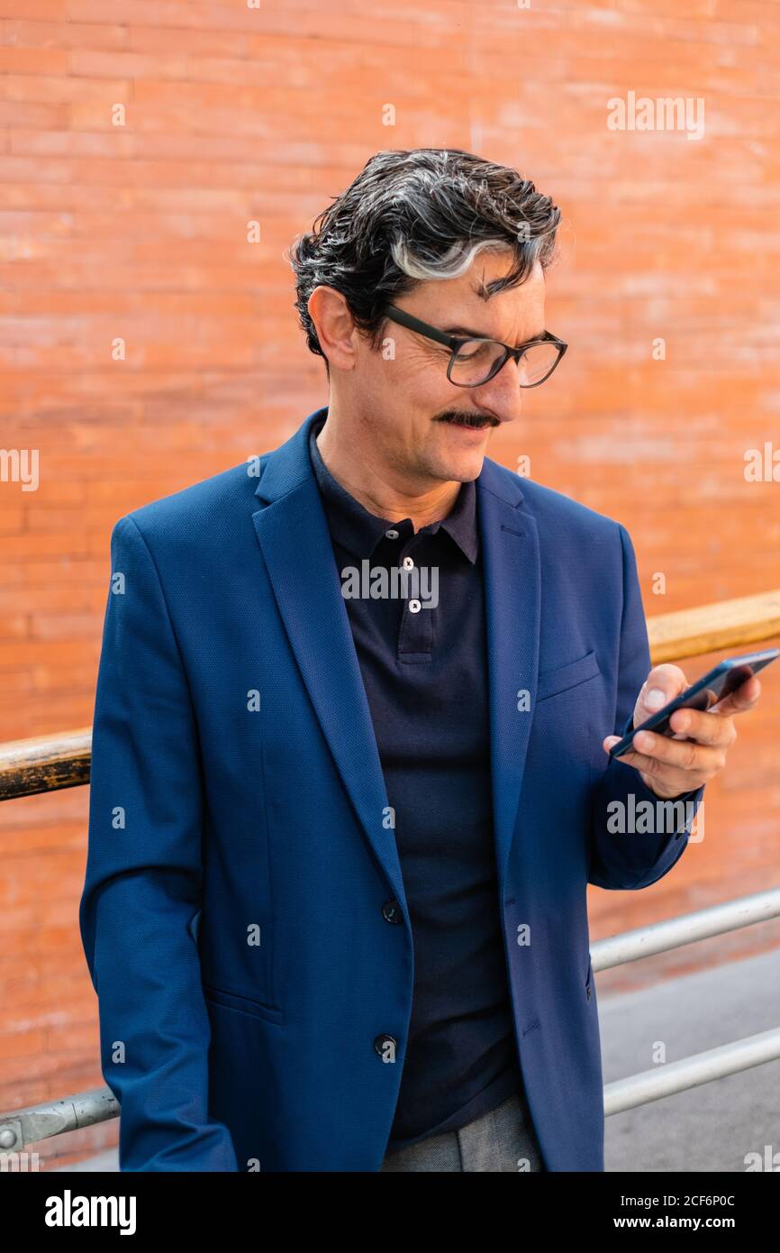 Senior businessman in blue jacket using smartphone Stock Photo