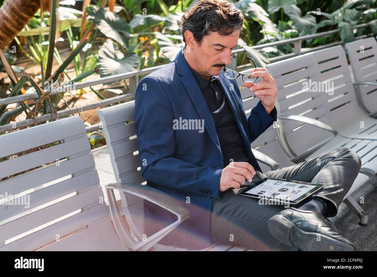 Aged handsome man using digital tablet outdoors Stock Photo