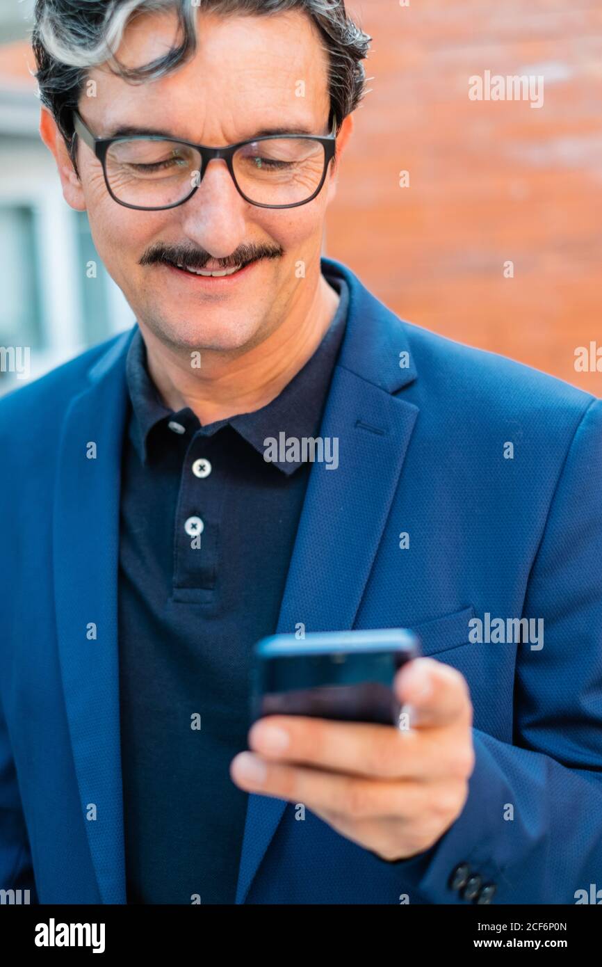 Senior businessman in blue jacket using smartphone Stock Photo