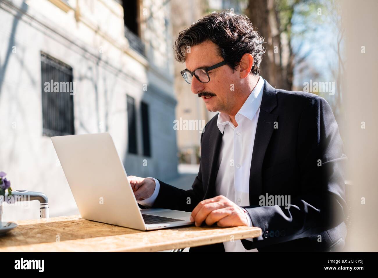 Elderly man using gadget while relaxing at cafe Stock Photo