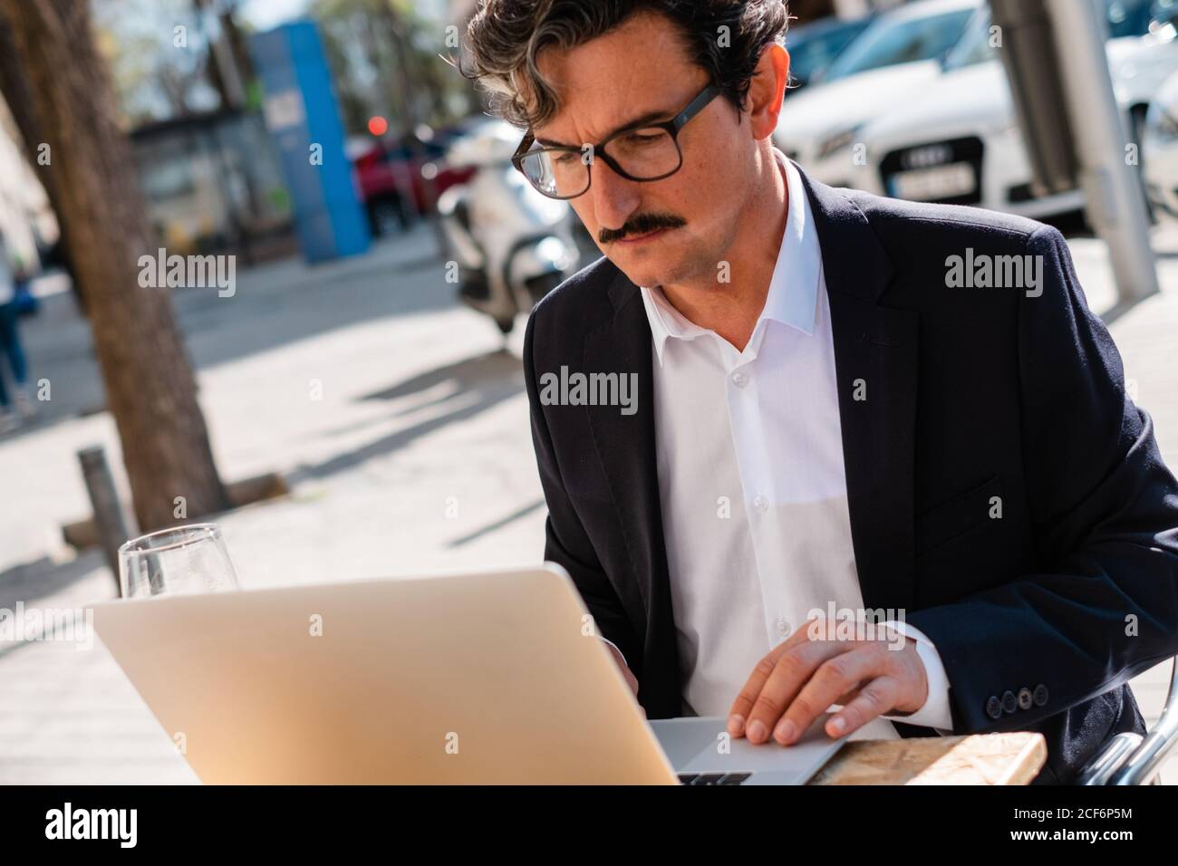 Elderly man using gadget while relaxing at cafe Stock Photo