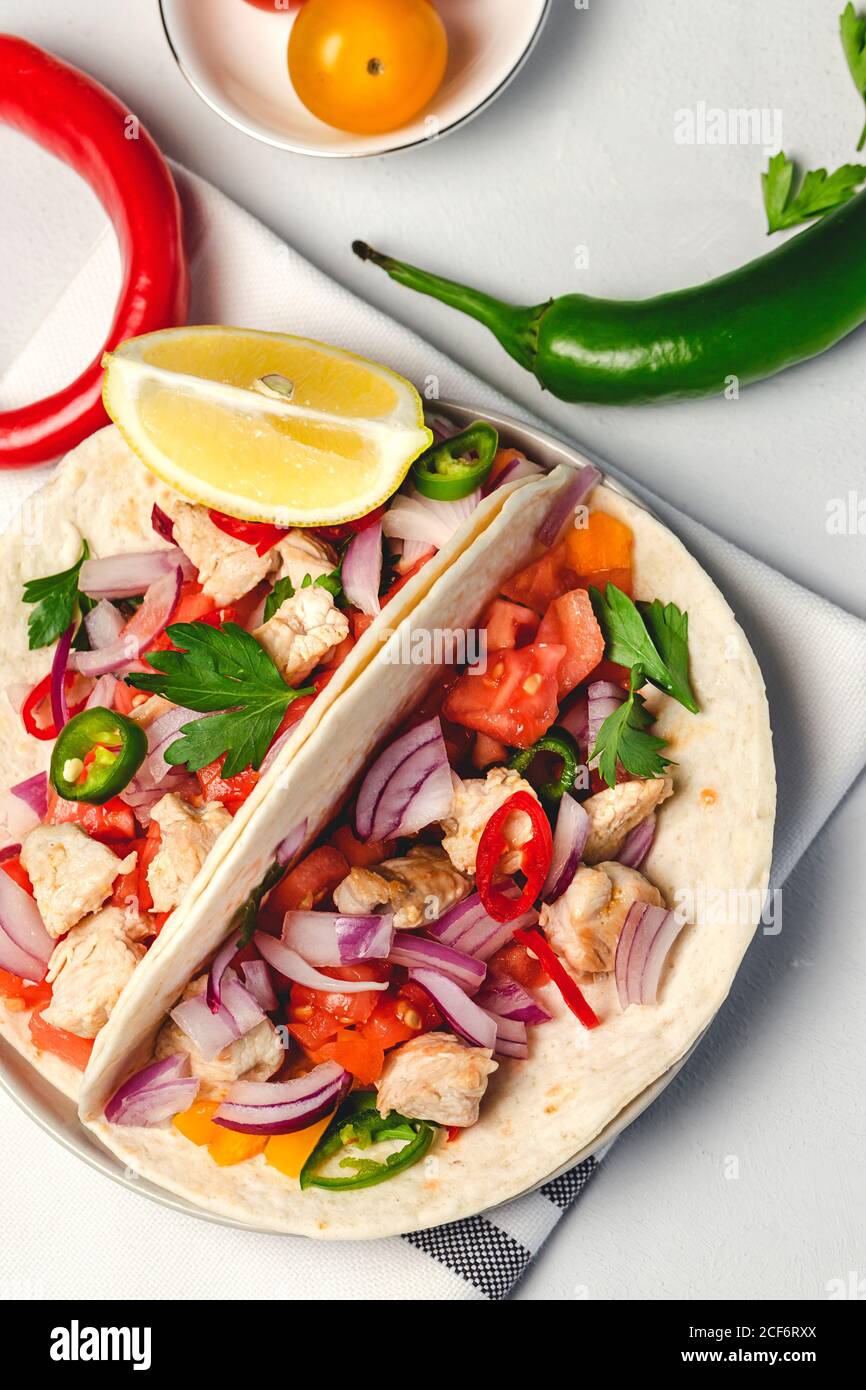 Homemade Mexican Tacos with fresh vegetables and chicken on white