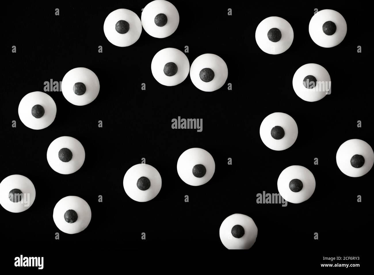 Halloween background, many white bulged eyes in the dark, black