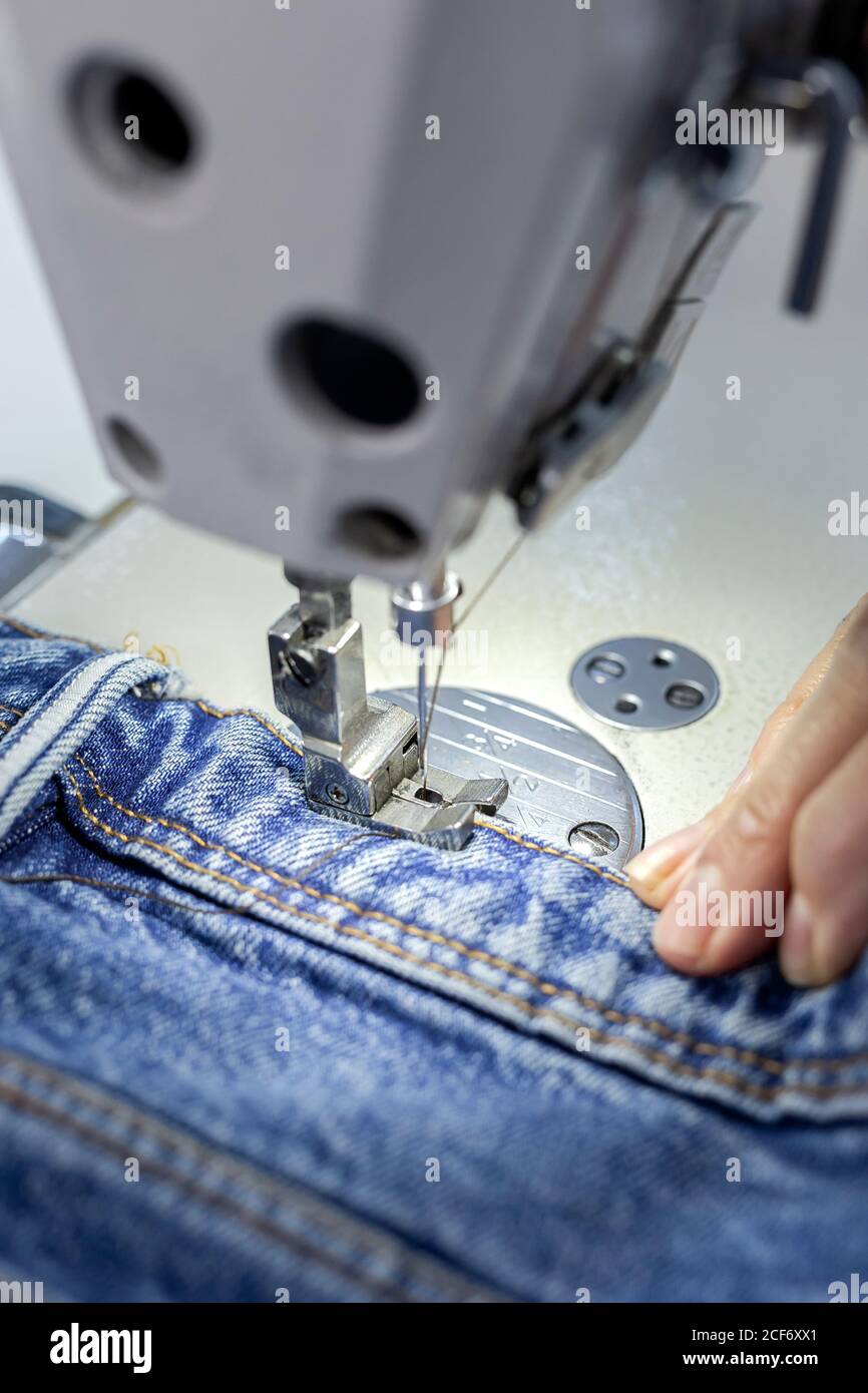 Working Woman hands in textile factory sewing on industrial sewing ...