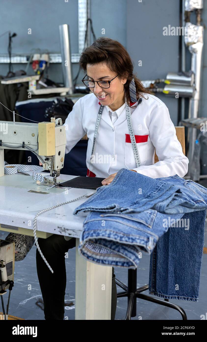 Working Woman hands in textile factory sewing on industrial sewing ...