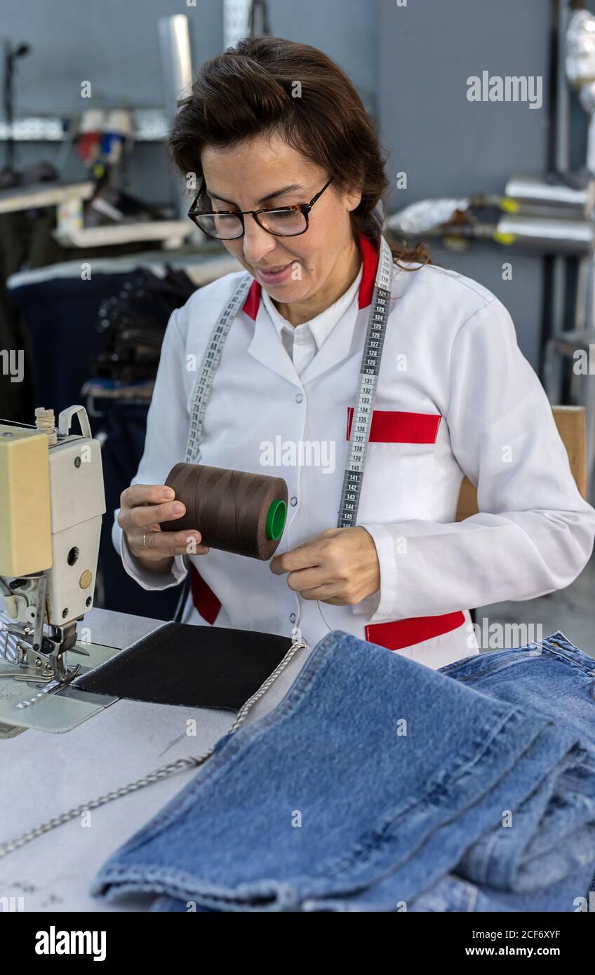 Working Woman hands in textile factory sewing on industrial sewing ...