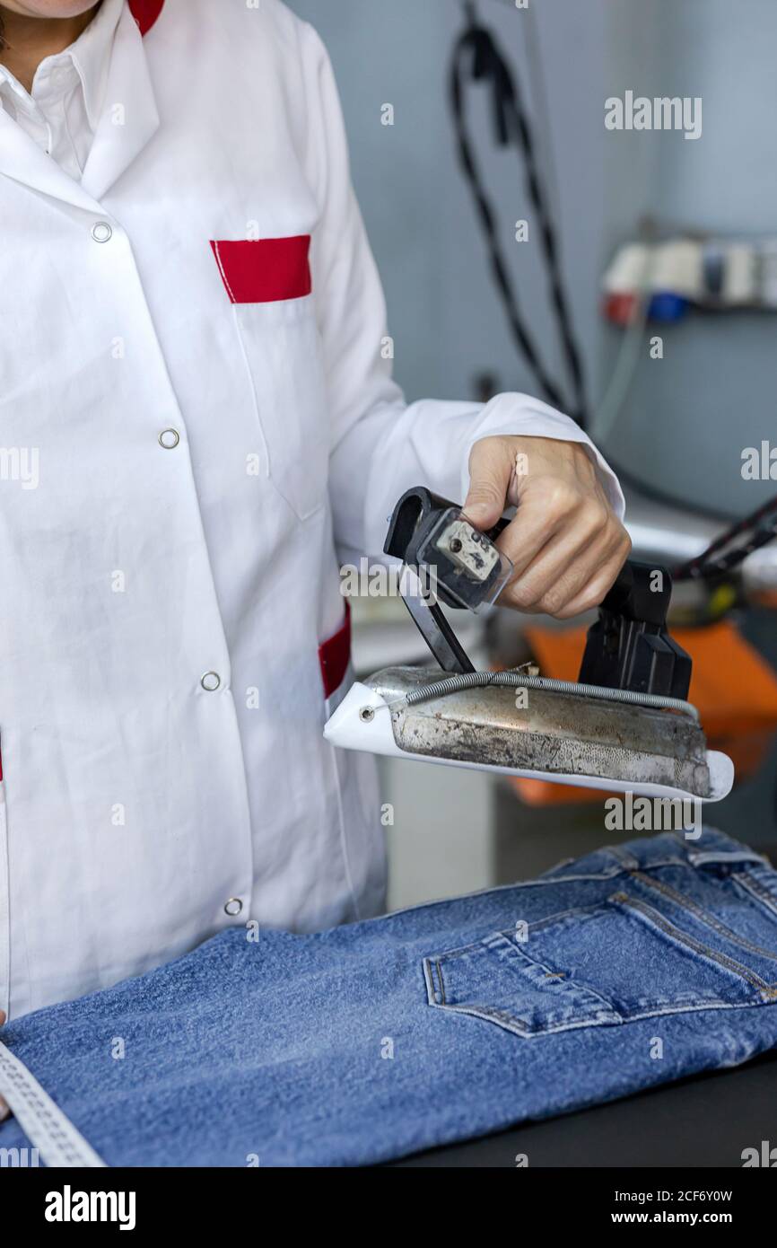 Working Woman hands in textile factory ironing on industrial sewing ...