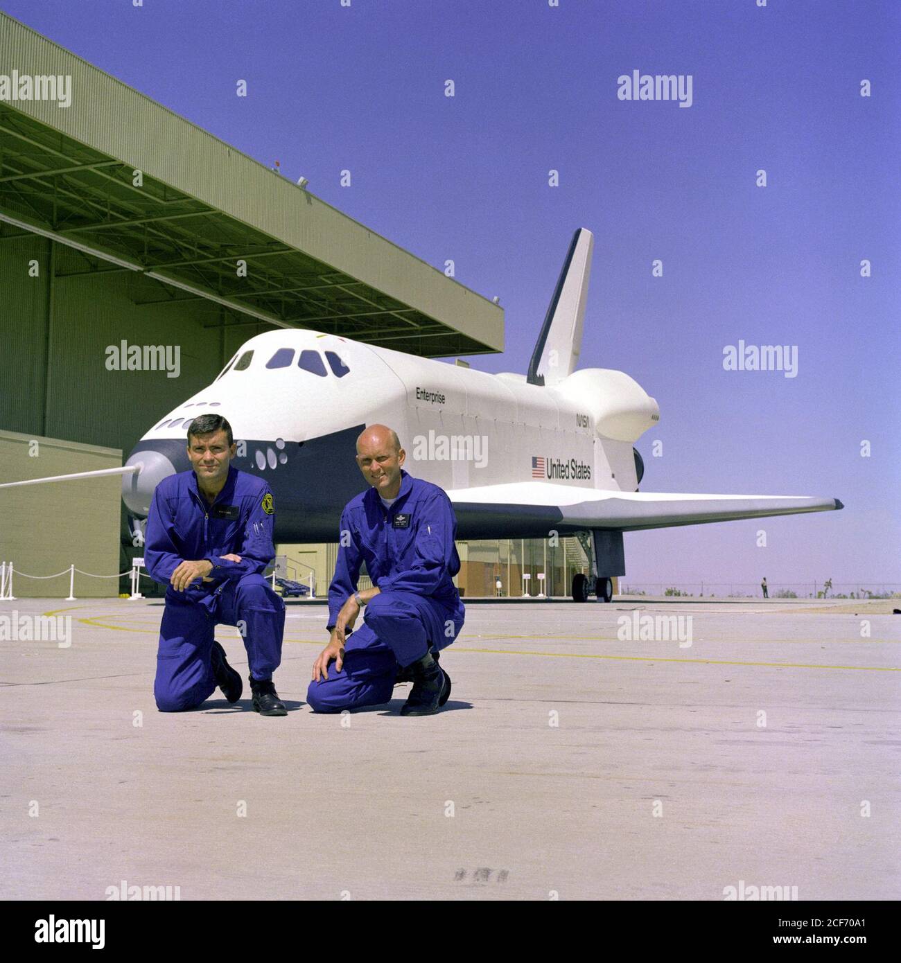 The first crew members for the Space Shuttle Approach and Landing Tests (ALT) are photographed at the Rockwell International Space Division's Orbiter Assembly Facility at Palmdale, California. The Shuttle Enterprise is Commanded by former Apollo 13 Lunar Module pilot, Fred Haise (left) with C. Gordon Fullerton as pilot. The Shuttle Orbiter Enterprise was named after the fictional Starship Enterprise from the popular 1960's television series, Star Trek. Stock Photo