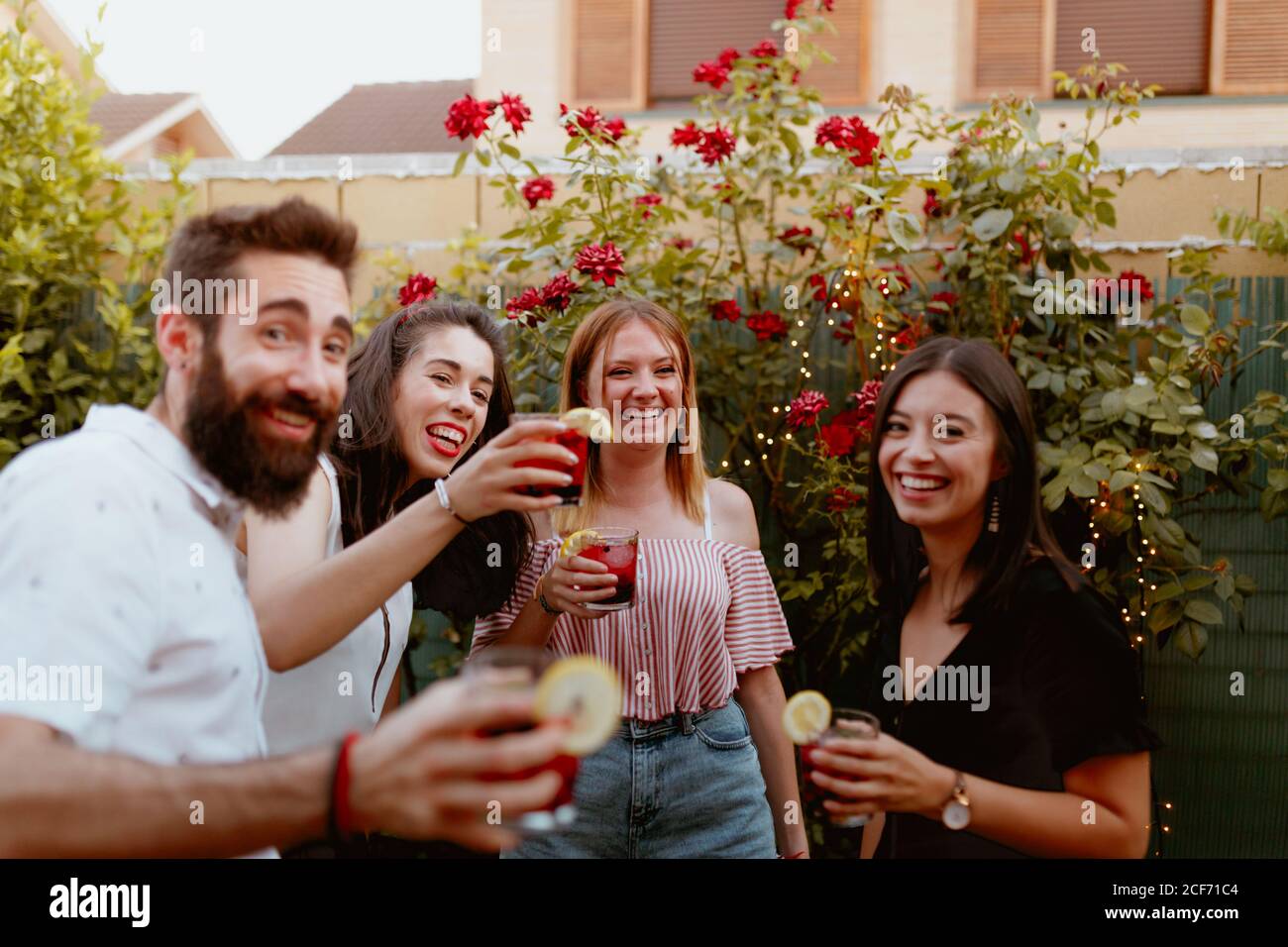 Group of cheerful friends clinking glasses at party Stock Photo