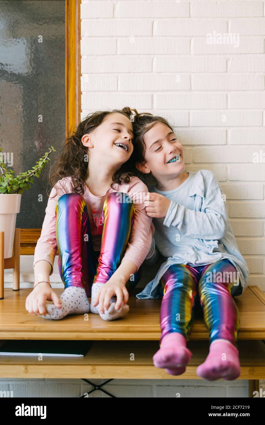 Two smiling sisters sticking out a blue tongue after eating a blue bubble gum Stock Photo