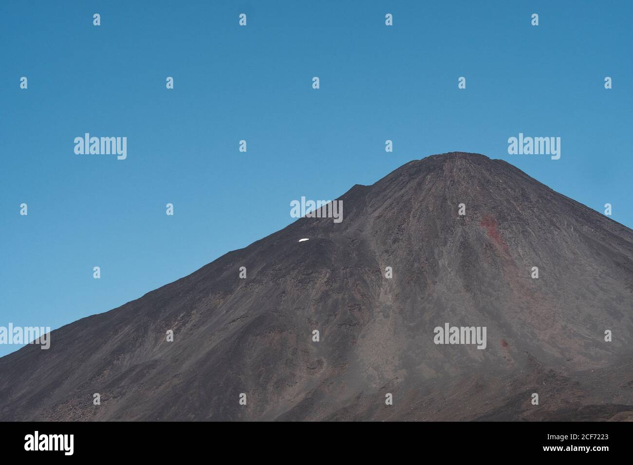 Gloomy lonely mountain peak under cloudy sky in rocky valley in Antuco Volcano Stock Photo