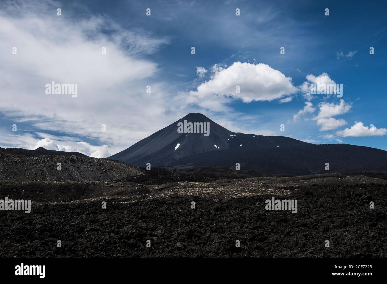 Gloomy lonely mountain peak under cloudy sky in rocky valley in Antuco Volcano Stock Photo