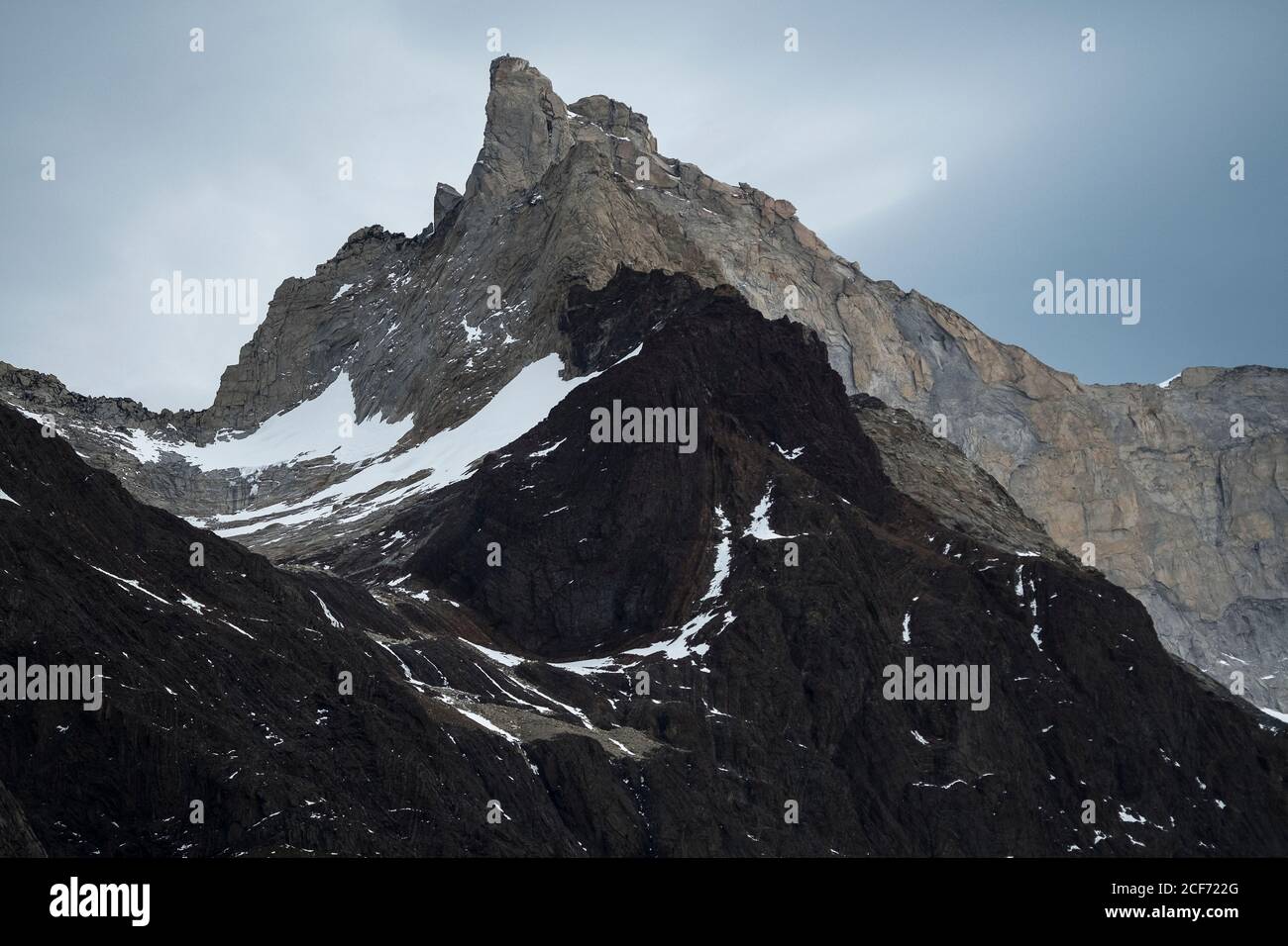 Gloomy lonely mountain peak under cloudy sky in rocky valley in Torres del Paine National Park Stock Photo