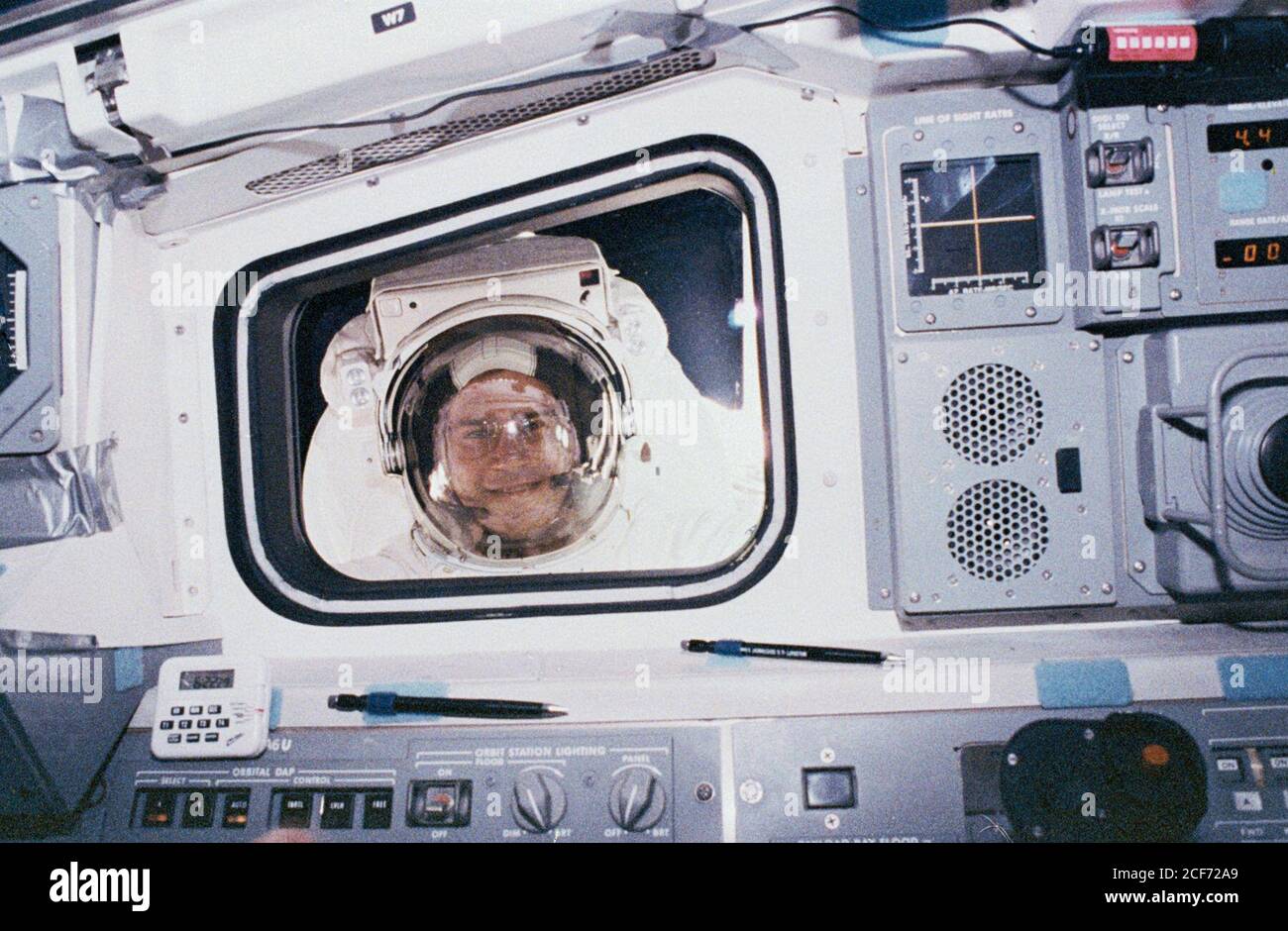 Rick Hieb, a Mission Specialist aboard STS-49, looks into the aft flight deck of the orbiter during his spacewalk. STS-49, which launched on May 7, 1992 and returned:to Earth on May 16, 1992, marked the first flight of Endeavour and the first shuttle mission to feature four EVAs. Hieb, along with fellow astronauts Pierre Thuot and Thomas Akers helped to recover INTELSAT VI, a communications satellite whose orbit had become unstable. Stock Photo