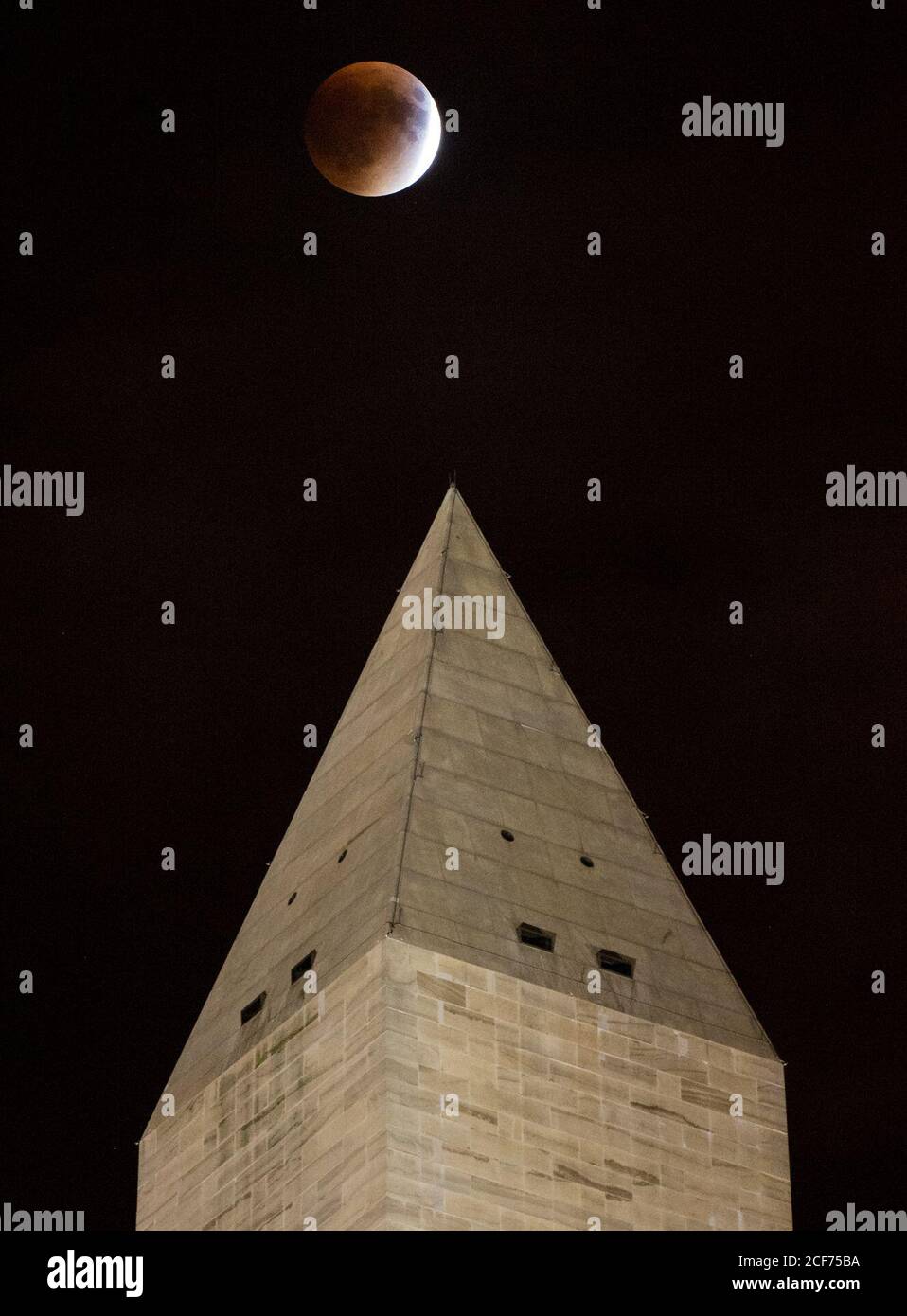 A perigee full moon, or supermoon, is seen behind the Washington Monument during a total lunar eclipse on Sunday, September 27, 2015, in Washington, DC. The combination of a supermoon and total lunar eclipse last occurred in 1982 and will not happen again until 2033.  Photo Credit: (NASA/Aubrey Gemignani) Stock Photo