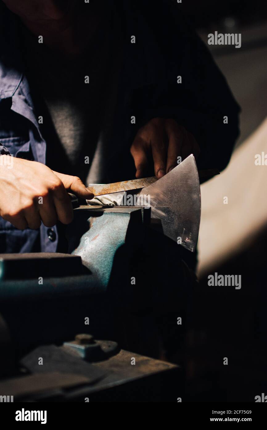 Crop craftsman checking axe in workshop Stock Photo