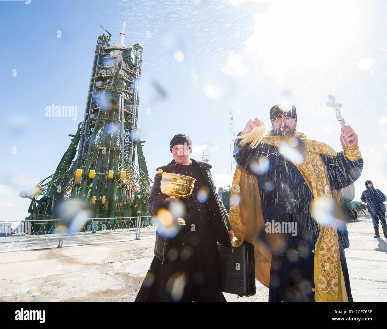 An Orthodox priest blesses members of the media at the Baikonur Cosmodrome launch pad on Thursday, March 17, 2016 in Kazakhstan.  Launch of the Soyuz rocket is scheduled for March 19 Baikonur time and will carry Expedition 47 Soyuz Commander Alexey Ovchinin of Roscosmos, Flight Engineer Jeff Williams of NASA, and Flight Engineer Oleg Skripochka of Roscosmos into orbit to begin their five and a half month mission on the International Space Station. Photo Credit: (NASA/Aubrey Gemignani) Stock Photo