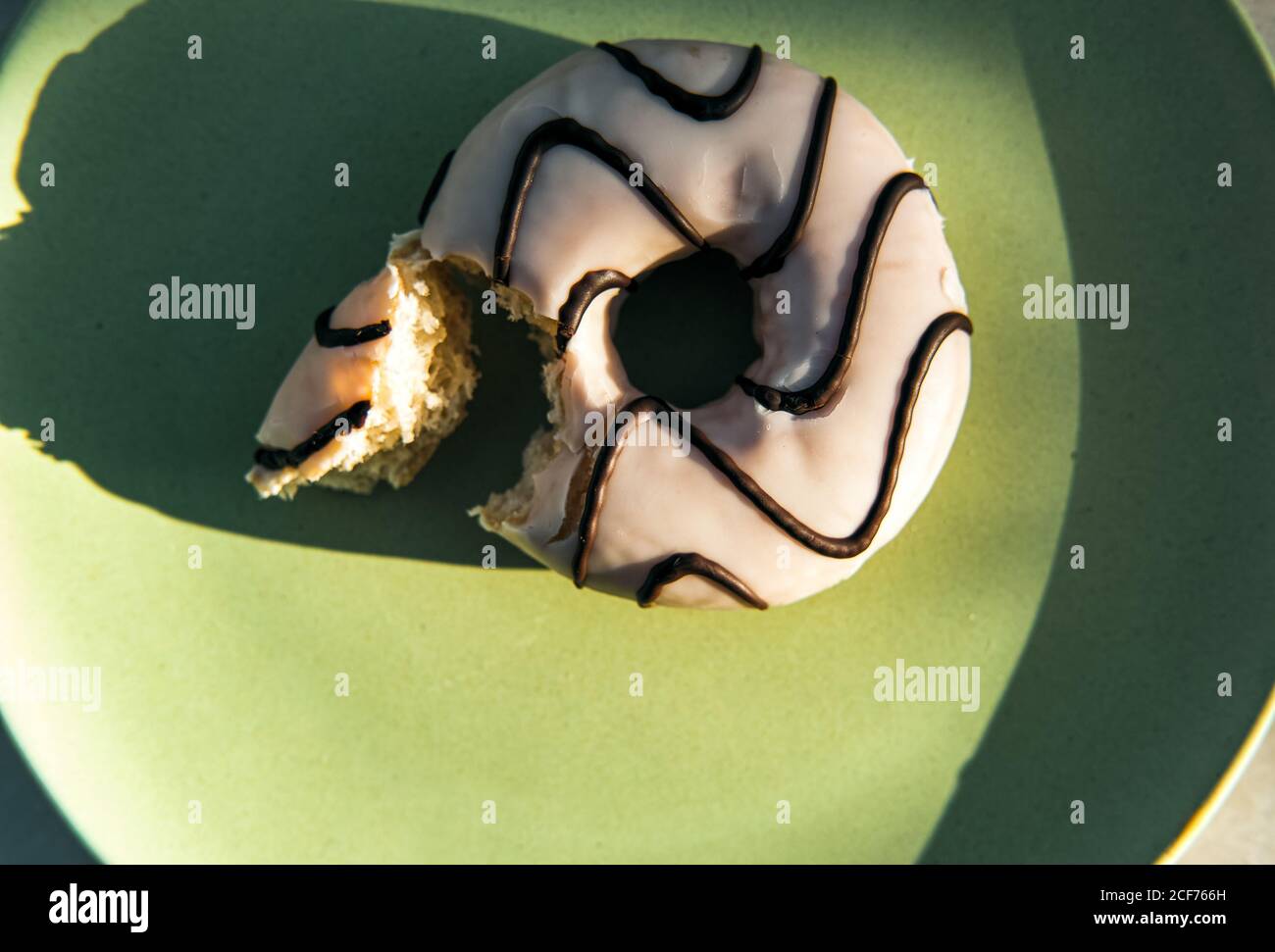 Donuts with icing and chocolate on plate Stock Photo