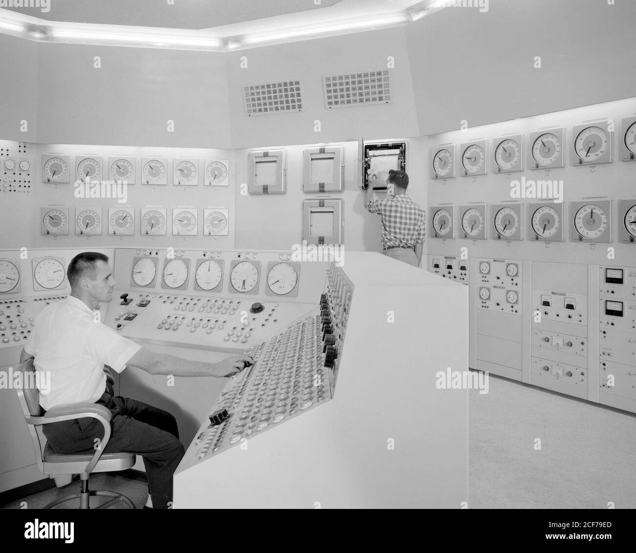 Bill Fecych (seated) and Don Johnson work in the reactor control room during its operating days in 1959. After an ad hoc committee study in 1977, NASA Headquarters decided that the reactor would never be put back into operation. Reactor equipment was then 'cannibalized' for other programs. Stock Photo